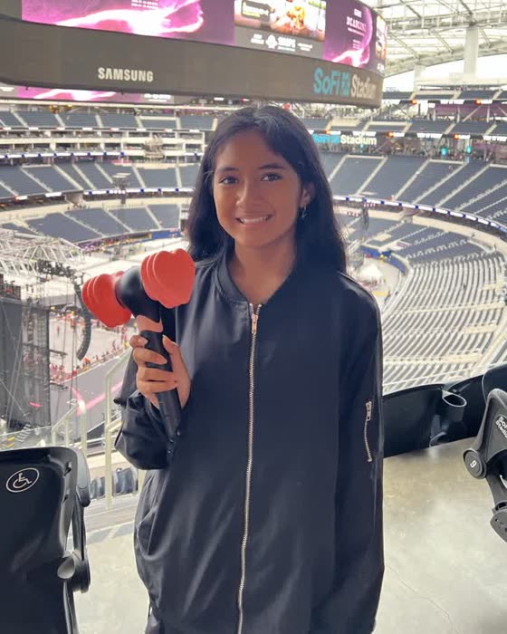 Kiana smiling at SoFi Stadium, holding a K-pop lightstick